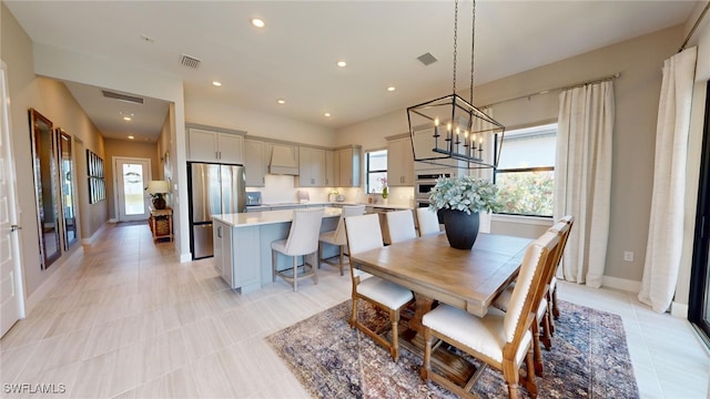 dining space featuring sink, an inviting chandelier, and light tile patterned floors