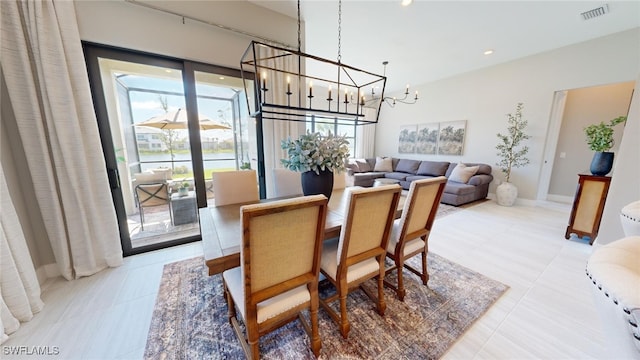 dining area with light tile patterned flooring, an inviting chandelier, and a wealth of natural light