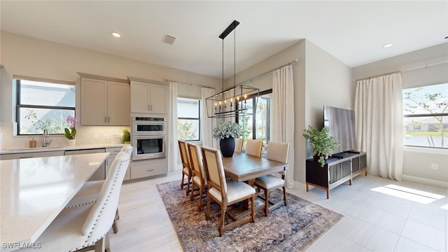 dining space with sink and a chandelier