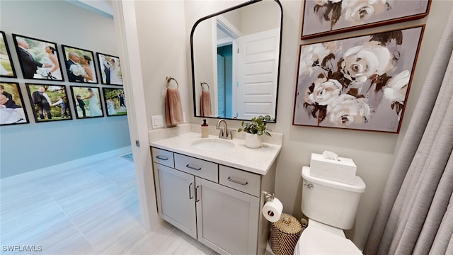 bathroom with toilet, tile patterned floors, and vanity