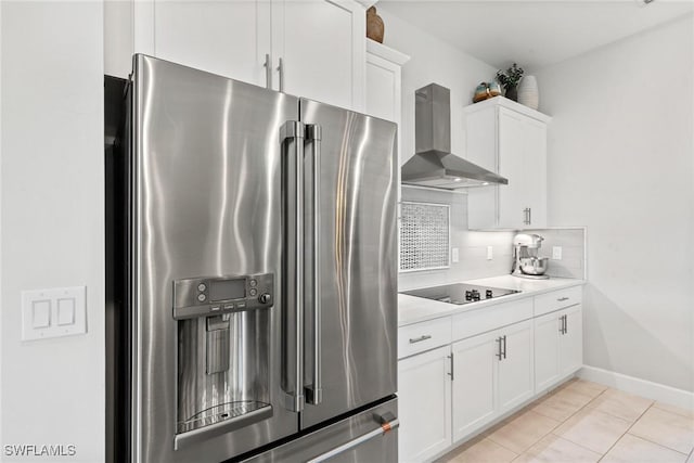 kitchen featuring wall chimney range hood, white cabinets, light tile patterned flooring, and stainless steel refrigerator with ice dispenser