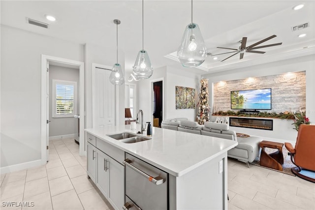 kitchen featuring ceiling fan, dishwasher, sink, decorative light fixtures, and a kitchen island with sink