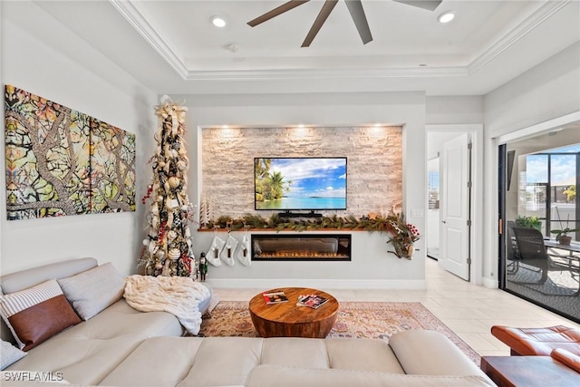 tiled living room featuring a tray ceiling, ceiling fan, and ornamental molding