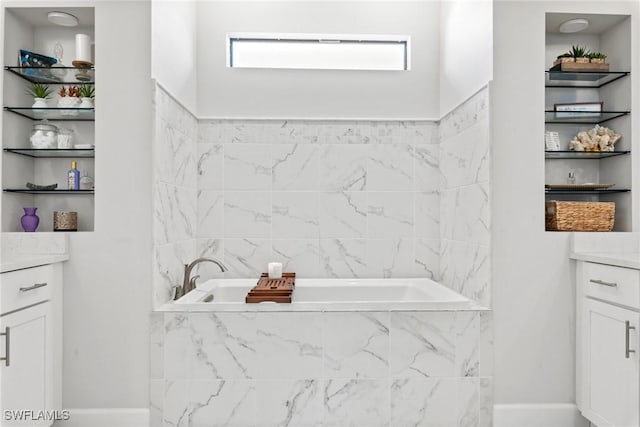 bathroom featuring vanity and tiled tub