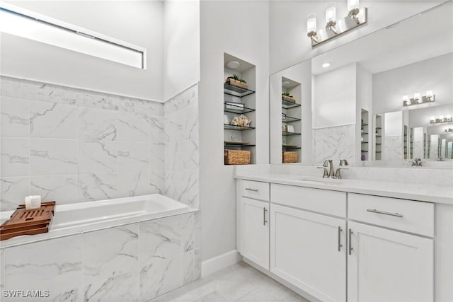 bathroom featuring vanity, built in features, and a relaxing tiled tub