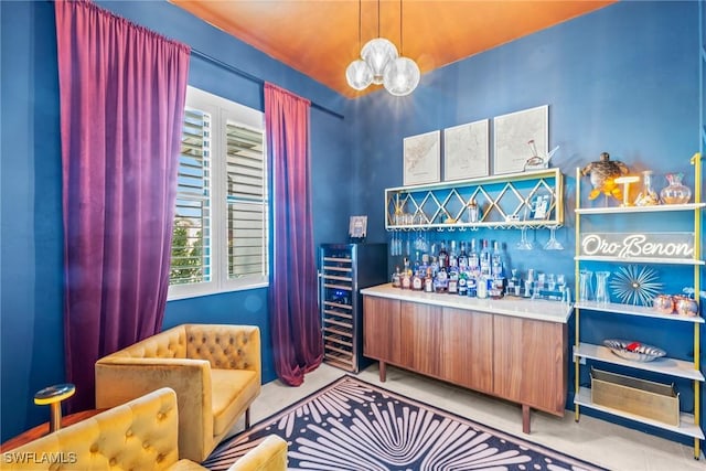 bar with beverage cooler, hanging light fixtures, and light tile patterned floors