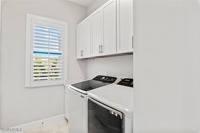 laundry room with light tile patterned floors, cabinets, and independent washer and dryer