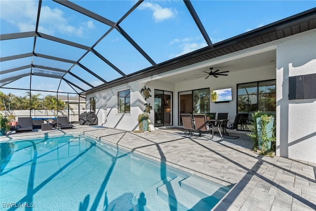 view of pool with ceiling fan, a lanai, an outdoor living space, and a patio