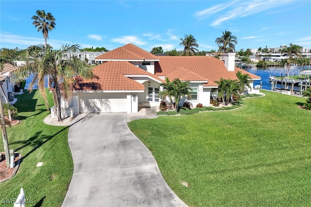 mediterranean / spanish-style house featuring a garage, a water view, and a front lawn