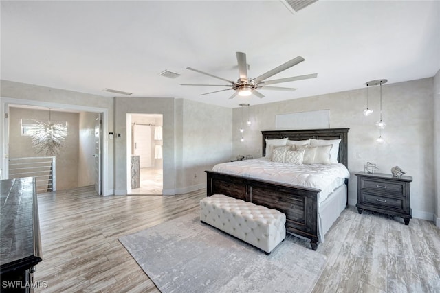 bedroom with ceiling fan with notable chandelier and light hardwood / wood-style flooring