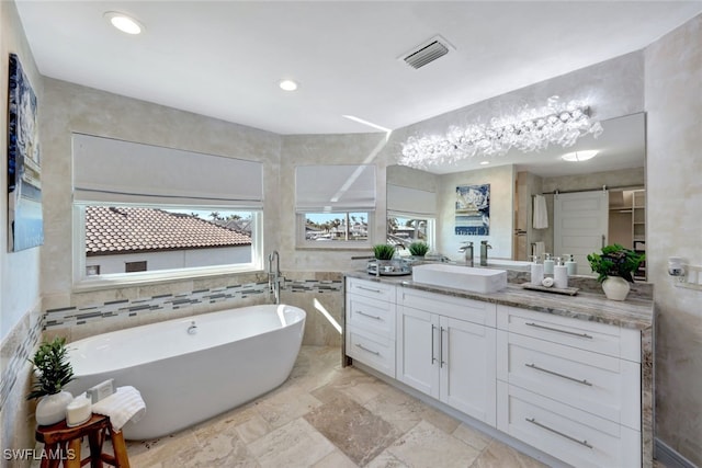 bathroom featuring a washtub, tile walls, and vanity