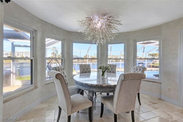 dining room with a water view and a notable chandelier