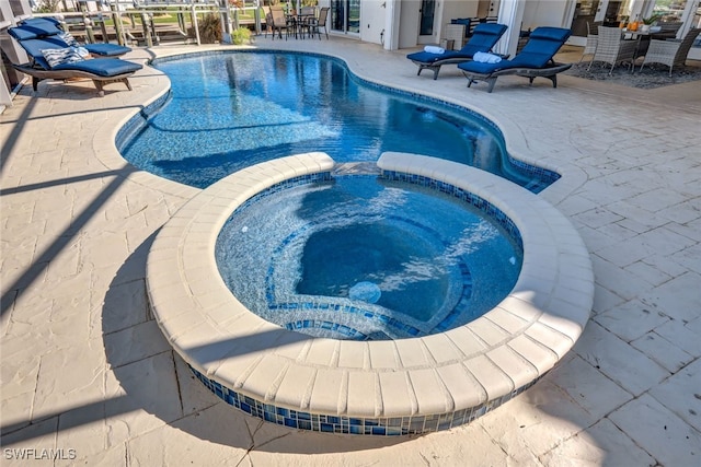 view of swimming pool with an in ground hot tub and a patio area