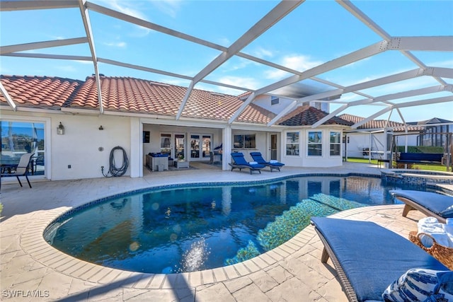 view of swimming pool with an in ground hot tub, french doors, a patio area, and a lanai