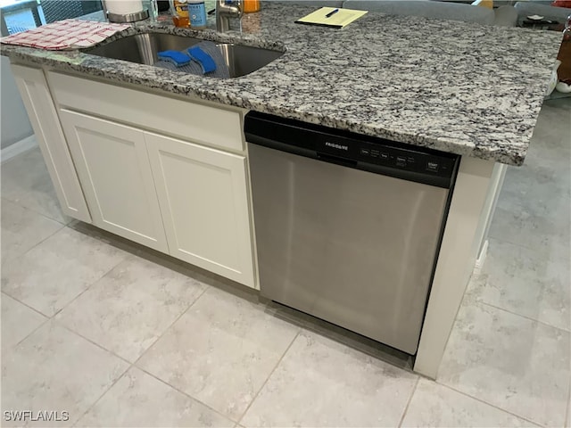 kitchen featuring stone counters, sink, white cabinets, and stainless steel dishwasher