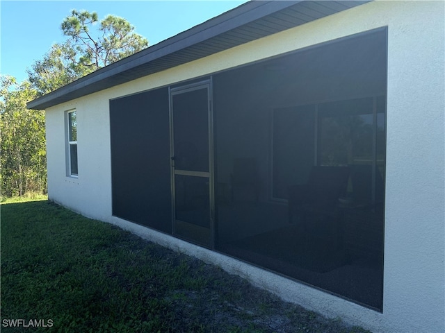 view of side of home featuring a yard and a sunroom