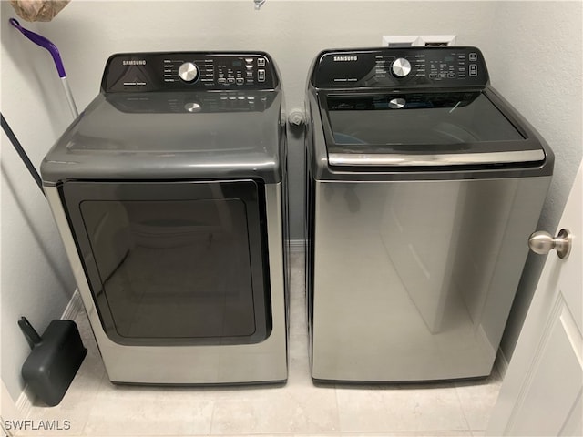 laundry room featuring tile patterned flooring and separate washer and dryer