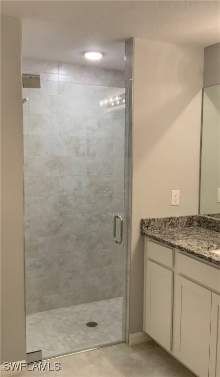 bathroom with tile patterned floors, vanity, and an enclosed shower