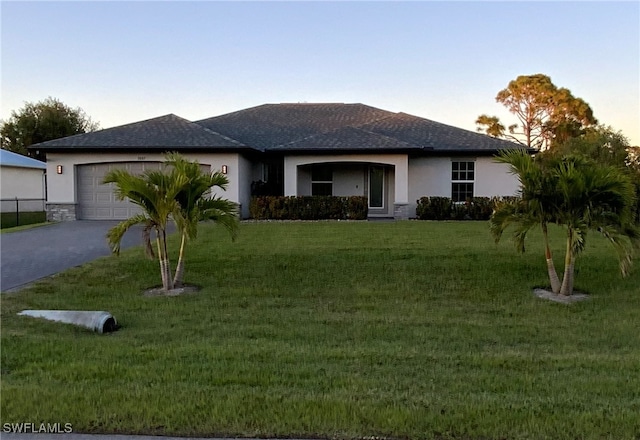 view of front of property featuring a garage and a yard