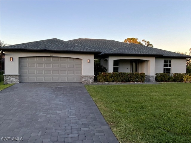 view of front of home with a garage and a yard