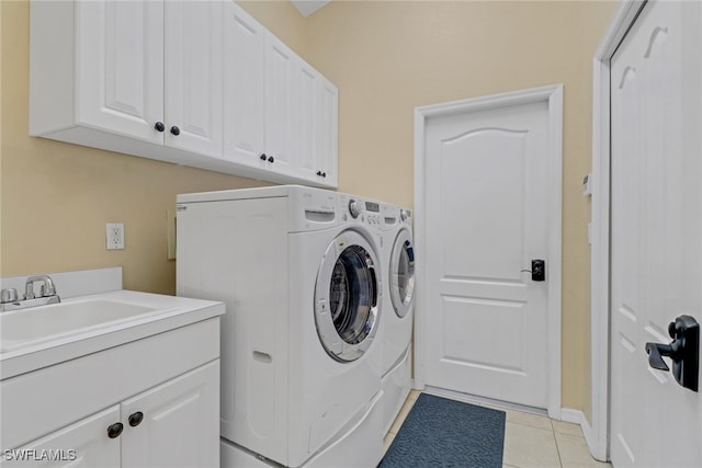 clothes washing area with cabinets, sink, light tile patterned floors, and washer and clothes dryer