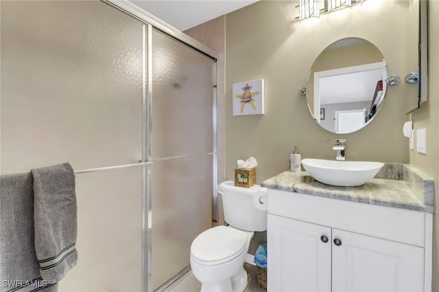 bathroom featuring vanity, walk in shower, and toilet