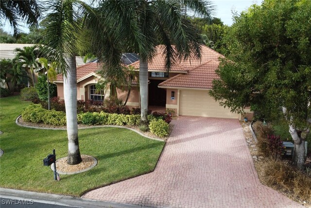 mediterranean / spanish-style home featuring a garage and a front yard