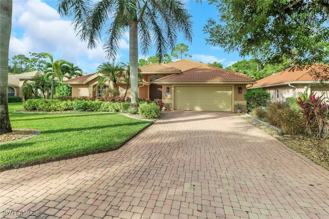 mediterranean / spanish-style house featuring a garage and a front yard