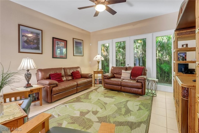 living room with a wealth of natural light, light tile patterned floors, and ceiling fan