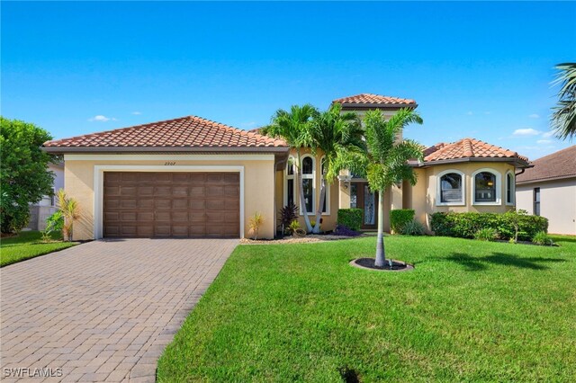 mediterranean / spanish home with a front yard and a garage