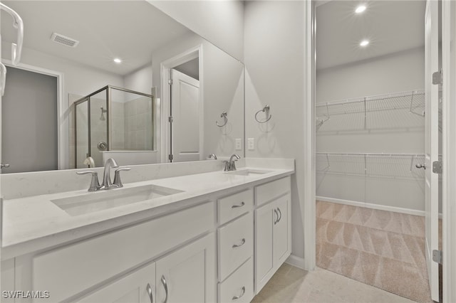 bathroom featuring tile patterned flooring, vanity, and walk in shower