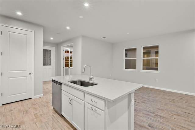 kitchen with sink, light hardwood / wood-style flooring, stainless steel dishwasher, an island with sink, and white cabinetry