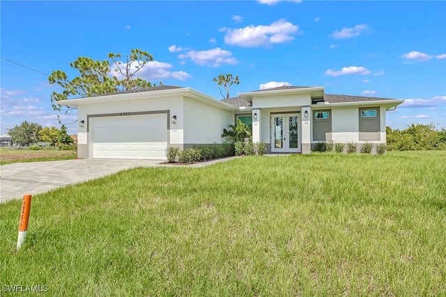 view of front of home with a front yard, french doors, and a garage