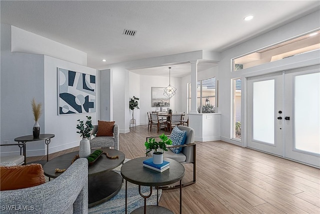 living room with french doors, wood-type flooring, and a textured ceiling