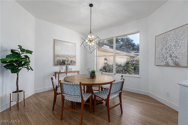 dining space featuring wood-type flooring and a notable chandelier