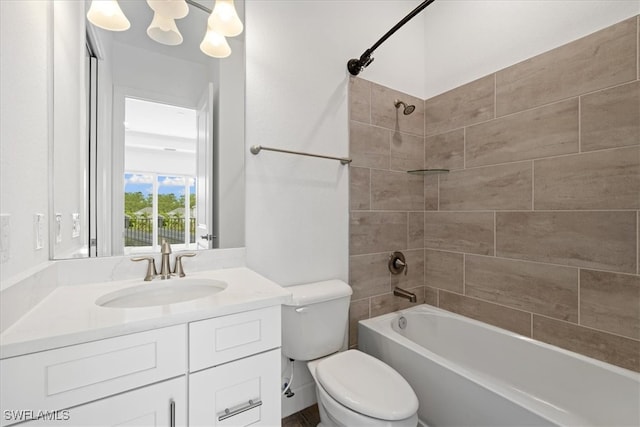 full bathroom with vanity, tiled shower / bath combo, and toilet