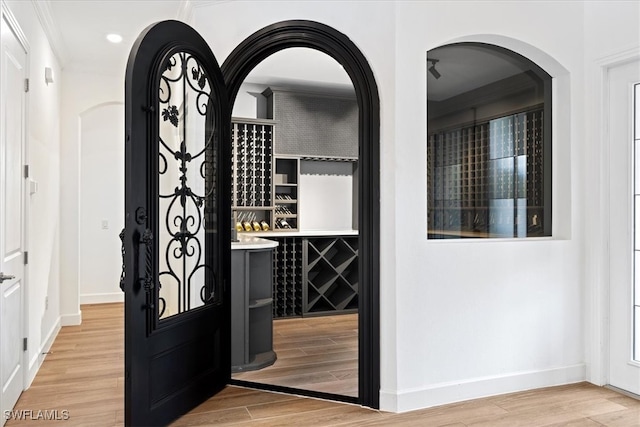 wine room with wood-type flooring and crown molding