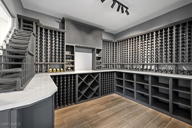 wine room featuring hardwood / wood-style floors and rail lighting