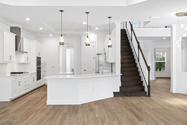 kitchen with white cabinets, pendant lighting, and light hardwood / wood-style flooring