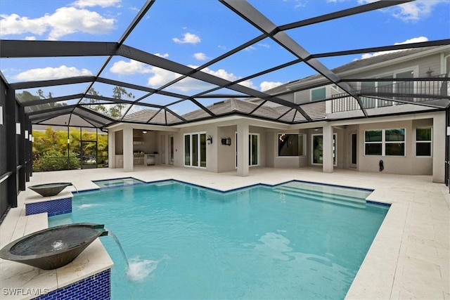 view of pool with pool water feature, glass enclosure, a patio area, and an in ground hot tub