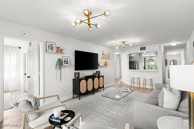 living room featuring light wood-type flooring and a chandelier