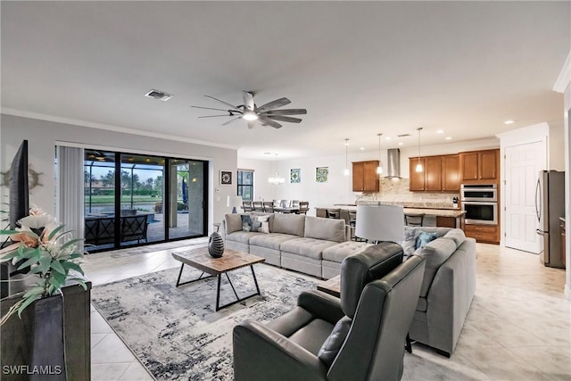 tiled living room featuring ceiling fan with notable chandelier and ornamental molding