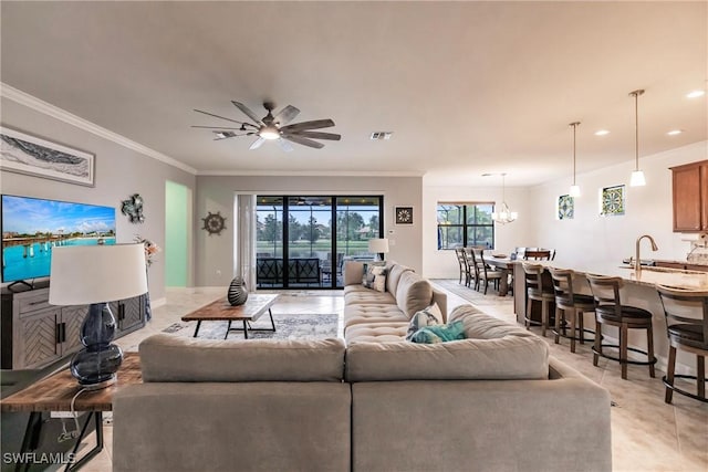 living room with ceiling fan with notable chandelier, crown molding, and sink