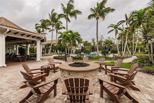 exterior space with ceiling fan, a pool, and an outdoor fire pit