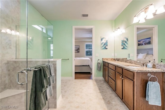 bathroom with tile patterned flooring, vanity, and a shower with door