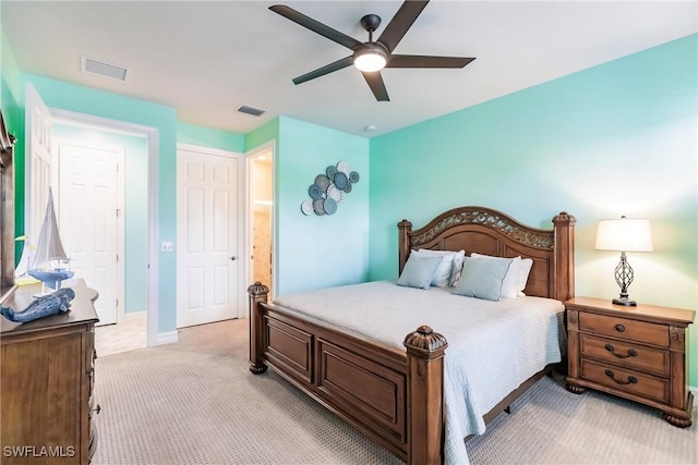 bedroom with ceiling fan, light carpet, and a closet