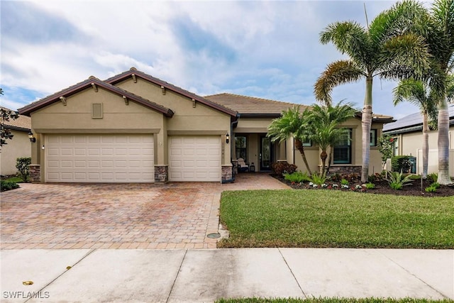 view of front of home with a front lawn, an attached garage, driveway, and stucco siding