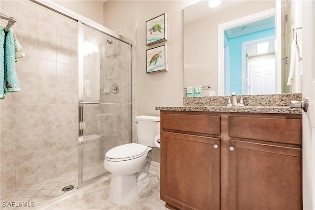 bathroom featuring tile patterned flooring, vanity, toilet, and a shower with shower door