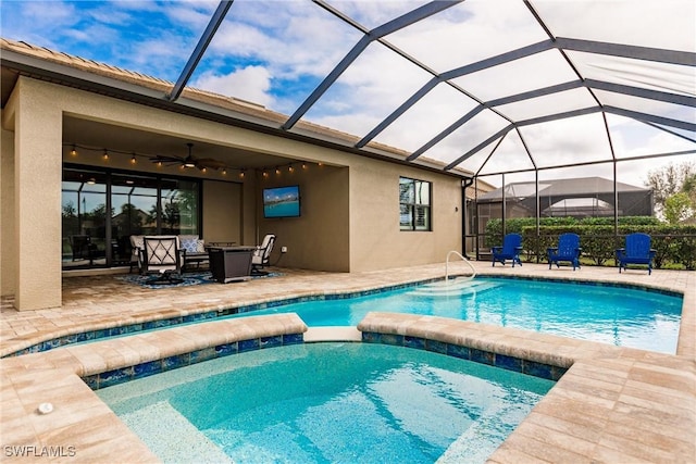 view of swimming pool with ceiling fan, a patio, and glass enclosure