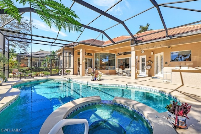 view of swimming pool with a lanai, a patio area, ceiling fan, and an in ground hot tub